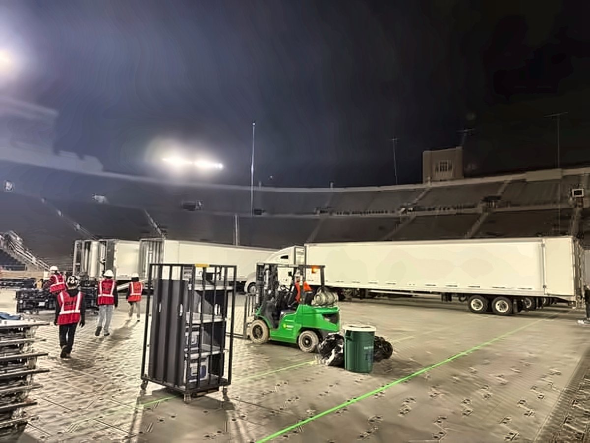 White trailers and a forklift on a stadium floor